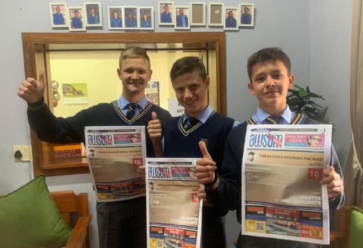Learners proudly holding their AWSUM News print editions
